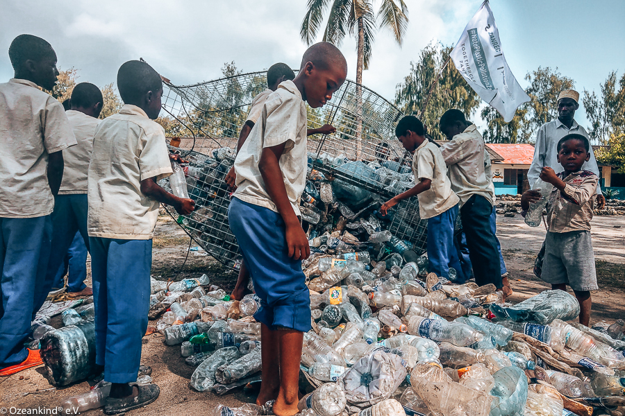 Junge Afrikaner beim Sammeln von Plastikmüll am Strand